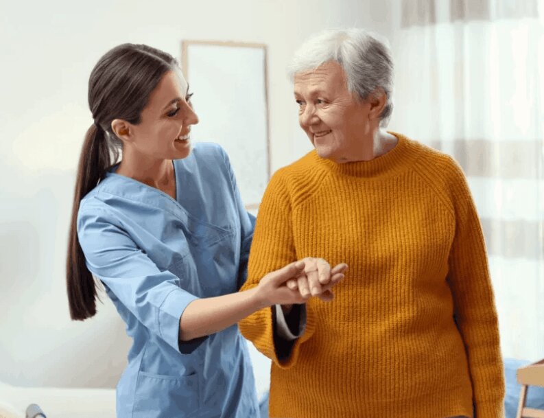 Cuidadora auxiliando uma idosa sorridente